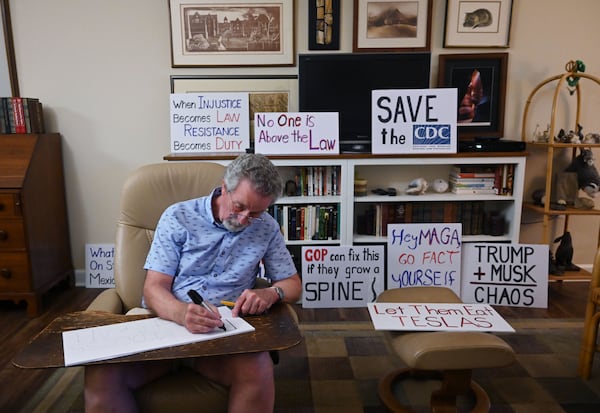 John Richmond makes a sign ahead of a protest against President Donald Trump at Mary Beth Thomas’ home in a Stone Mountain retirement community on Thursday, May 1, 2025. (Hyosub Shin/AJC)