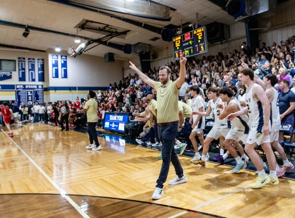 St. Pius coach Will Cloyd and the Golden Lions take to the court at the buzzer of the Class 4A state playoff quarterfinal win over North Oconee on Wednesday, March 4, 2026, in Atlanta. (Jenni Girtman for the AJC)