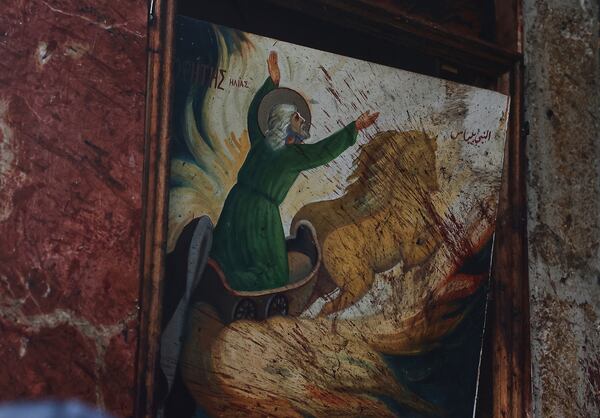 Blood spread on a poster inside Mar Elias church where a suicide bomber detonated himself in Dweil'a in the outskirts of Damascus, Syria, Sunday June 22, 2025. (AP Photo/Ghaith Alsayed)