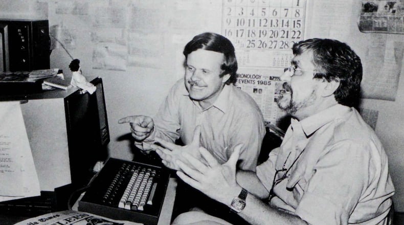 In this undated photo published in The AP World in 1986, Manila bureau chief David Briscoe, left, and Asia news director Richard Pyle discuss a story. (AP Photo)