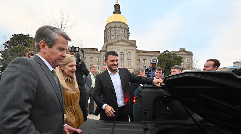 December 16, 2021 Atlanta - Jimmy Knauf EVP of Facilities at Rivian, smiles as he shows Rivian R1T electric truck to Georgia Governor Brian Kemp (left) and First Lady Marty Kemp (second from left) during a press conference at Liberty Plaza across from the Georgia State Capitol in Atlanta on Thursday, December 16, 2021. Electric vehicle maker Rivian on Thursday confirmed its plans to build a $5 billion assembly plant and battery factory in Georgia, which Gov. Brian Kemp called Òthe largest single economic development project ever in this stateÕs history.Ó (Hyosub Shin / Hyosub.Shin@ajc.com)