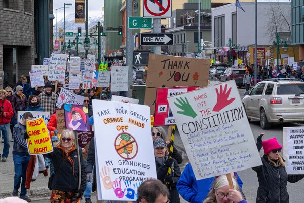 People walk through downtown Anchorage, Alaska, to protest against President Trump and his policies on Saturday, April 19, 2025. (Loren Holmes/Anchorage Daily News via AP)
