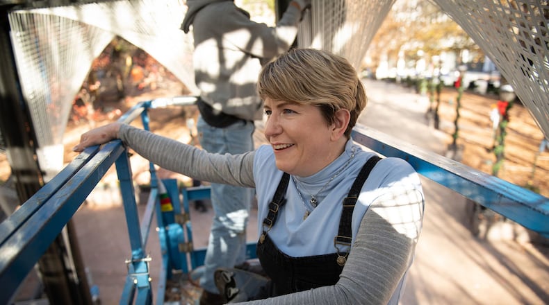 Megan Mosholder works on her light-based sculpture as part of “PRISM: Winter Lights in Woodruff Park.” PHOTO BY ELISSA BENZIE