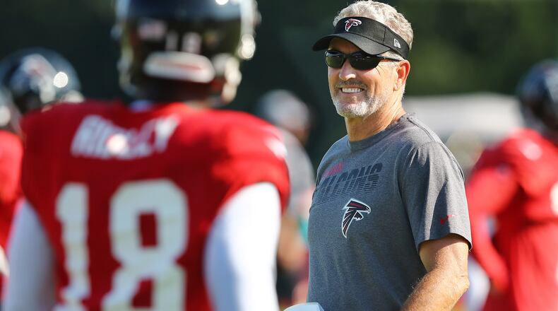 Falcons offensive coordinator Dirk Koetter works with wide receiver Calvin Ridley before he exited practice with an apparent hamstring injury, Thursday, July 25, 2019, in Flowery Branch.