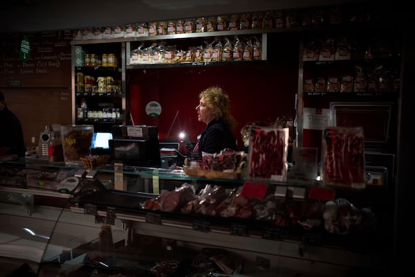 Vendors use their phone light to select and save some food, during a major power outage in Barcelona, Spain, Monday, April 28, 2025. (AP Photo/Emilio Morenatti)