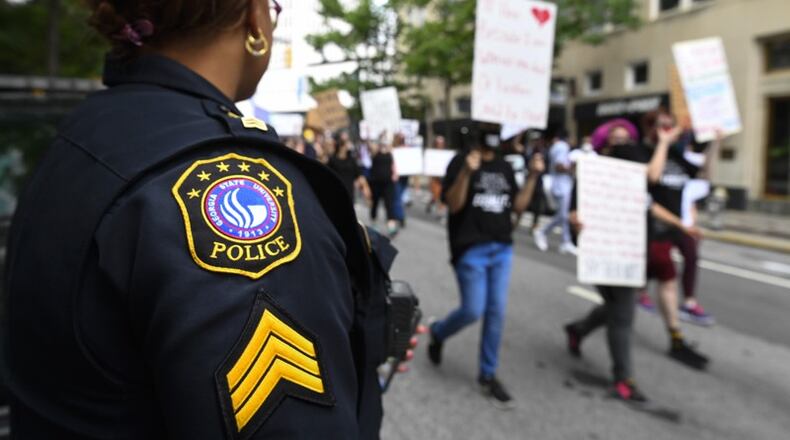 A Georgia State University police officer looked on as demonstrators marched against police brutality on June 6. Some Black police officers contended they supported the plight of the protestors.JOHN AMIS/ FOR THE ATLANTA JOURNAL-CONSTITUTION