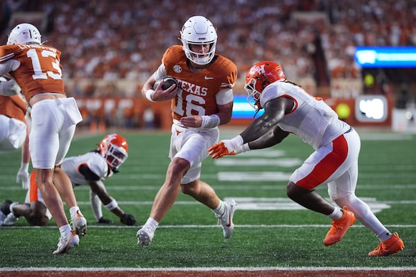Texas quarterback Arch Manning (center) runs past Sam Houston State linebacker Antavious Fish to score a touchdown on Saturday, Sept. 20, 2025, in Austin, Texas. Manning, once a high-priority Georgia target, will have five more games under his belt by the time the Longhorns come to Athens. (Eric Gay/AP)