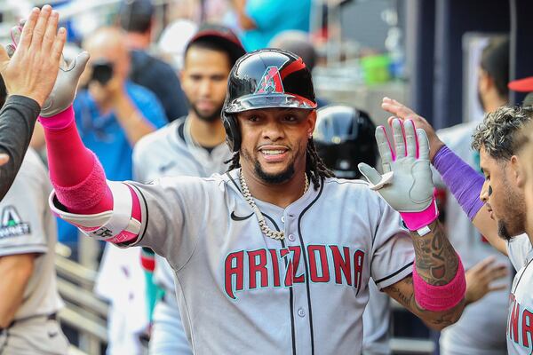 Arizona Diamondbacks' Ketel Marte high-fives teammates in the dugout after hitting a solo home run in the first inning of a baseball game against the Atlanta Braves, Tuesday, June 3, 2025, in Atlanta. (AP Photo/Colin Hubbard)