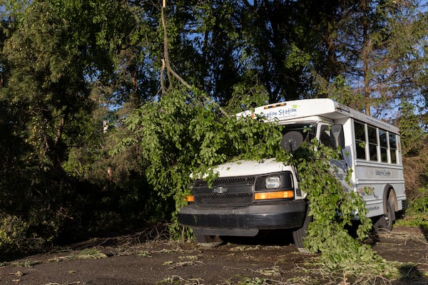 A tree branch covers a bus in Dorr, Mich., after a severe storm ripped across Michigan the night before, on Friday, May 16. 2025. (Neil Blake /The Grand Rapids Press via AP)