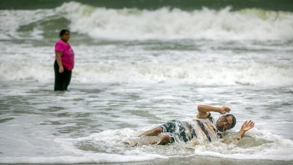 TYBEE ISLAND, GA - AUGUST 30, 2023: A visitor reacts as he is hit by a wave from Hurricane IdaliaÕs storm surge near the Tybee Pier, Wednesday, Aug. 30, 2023, in Tybee Island, Ga. (AJC Photo/Stephen B. Morton)