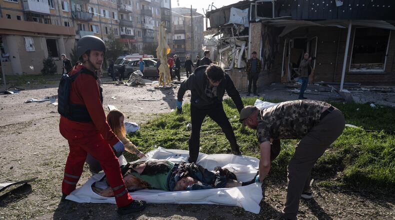 EDS NOTE: GRAPHIC CONTENT - In this photo provided by Ukraine's 93rd Kholodnyi Yar Separate Mechanized Brigade press service, people cover bodies of civilians killed in Russia's aerial guided bomb attack in Kramatorsk, Donetsk region, Ukraine, Tuesday, May 5, 2026. (Iryna Rybakova/Ukraine's 93rd Mechanized Brigade via AP)