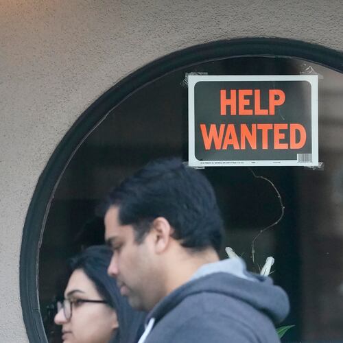 FILE - Pedestrians walk past a help wanted sign posted on the door of a restaurant in San Francisco, Tuesday, April 18, 2023. (AP Photo/Jeff Chiu, File)
