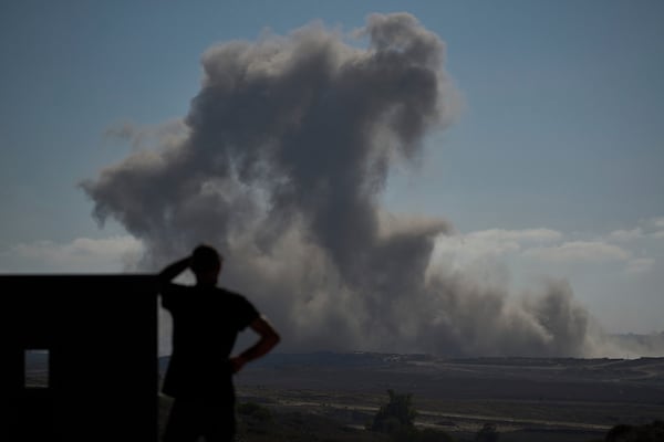 A man looks at smoke rising to the sky following an Israeli bombardment in the northern Gaza Strip, as seen from southern Israel, Tuesday, July 8, 2025. (AP Photo/Leo Correa)