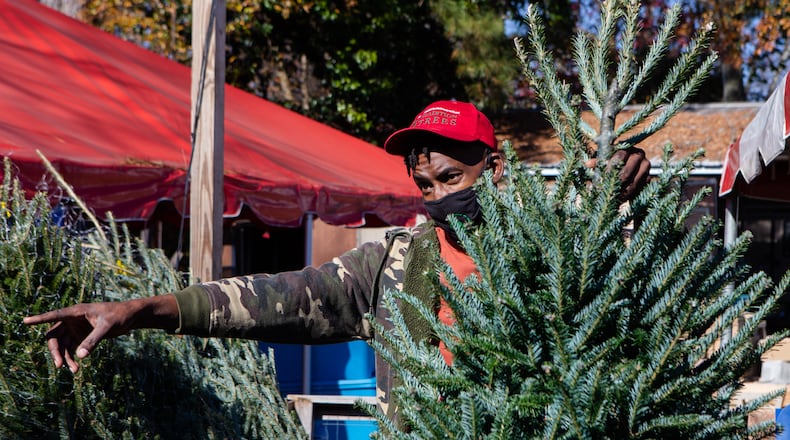 Jonathan Fox, a worker at Tradition Trees, speaks to a customer on Friday, Dec. 17, 2020, at Traditions Trees in Atlanta. Tradition Trees is one of the few Christmas tree sellers with trees still in stock. CHRISTINA MATACOTTA FOR THE ATLANTA JOURNAL-CONSTITUTION.
