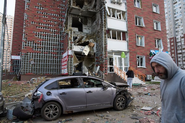 Residents react near their damaged multi-storey building damaged in Russia's missile and drone attack in Kyiv, Ukraine, Tuesday, June 10, 2025. (AP Photo/Efrem Lukatsky)