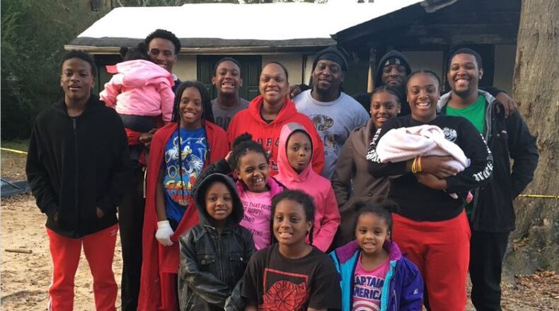 Victoria Natt (center in red hoodie) and Tevares Natt (in gray to right of Victoria) and their 14 children managed to escape the fire that destroyed their Marietta home early in the morning on Nov. 14, but they lost everything. Image credit: WSB-TV via Twitter
