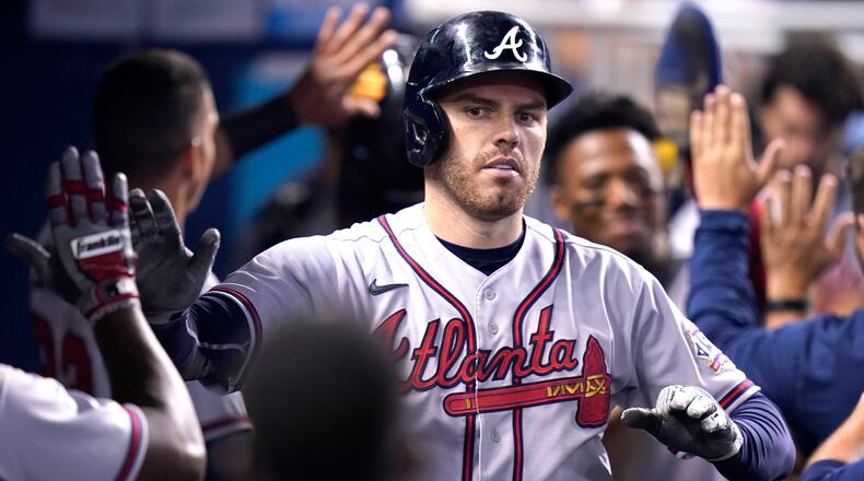 Atlanta Braves' Freddie Freeman is congratulated in the dugout after hitting a two-run home run during the fifth inning of a baseball game against the Miami Marlins, Saturday, July 10, 2021, in Miami. (AP Photo/Lynne Sladky)