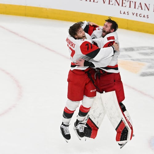 Carolina Hurricanes left wing Mark Jankowski (77) and goaltender Brandon Bussi (32) celebrate after a win over the Vegas Golden Knights in Game 6 of the NHL hockey Stanley Cup Final series, Sunday, June 14, 2026, in Las Vegas. (AP Photo/Candice Ward)