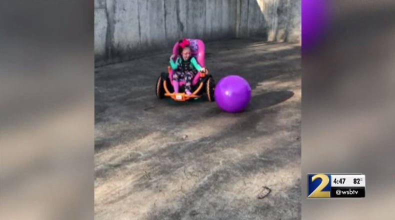 Kessley Hales, 6, plays in a new ATV built specifically for her by Etowah High School's robotics team.
