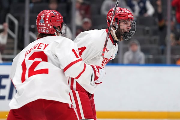 Boston University's Jack Hughes, right, celebrates after scoring as teammate Jack Harvey (12) watches during the second period in a semifinal game in the NCAA Frozen Four men's college hockey tournament against Penn State, Thursday, April 10, 2025, in St. Louis (AP Photo/Jeff Roberson)
