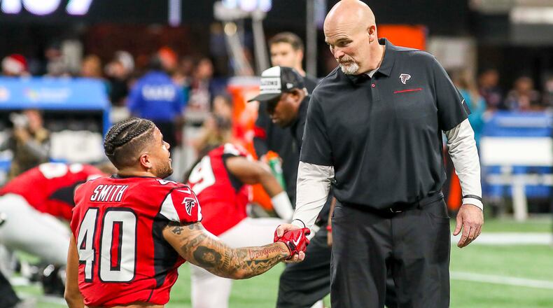 Atlanta Falcons head coach Dan Quinn speaks with running back Keith Smith (40) before the start of final home game Sunday, Dec. 22, 2019, against the Jacksonville Jaguars at Mercedes-Benz Stadium in Atlanta.