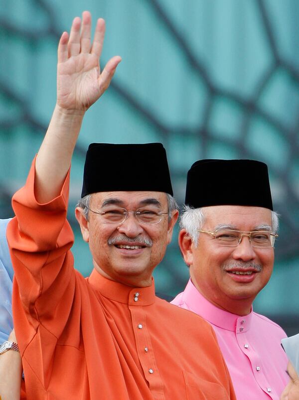 FILE - Malaysia's former Prime Minister Abdullah Ahmad Badawi, left, waves as new Prime Minister Najib Razak smile behind at Prime Minister office in Putrajaya, April 3, 2009. (AP Photo/Vincent Thian, File)