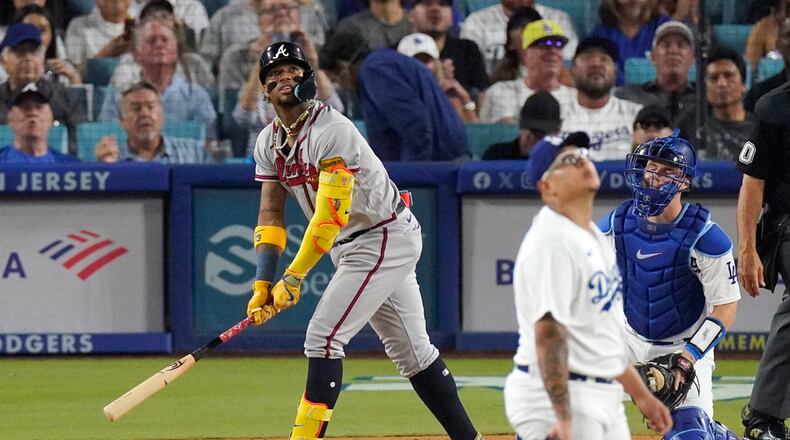 Atlanta Braves' Ronald Acuna Jr., left, heads to first after hitting a solo home run as Los Angeles Dodgers starting pitcher Julio Urias, center, and catcher Will Smith watch during the third inning of a baseball game Friday, Sept. 1, 2023, in Los Angeles. (AP Photo/Mark J. Terrill)