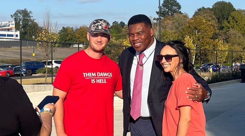 Herschel Walker, the University of Georgia football standout who ran unsuccessfully for U.S. Senate in 2022, poses with fans outside former President Donald Trump's rally in Macon on Nov. 3, 2024.