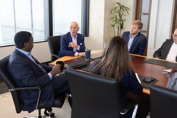 Eric Tanenblatt (center), Dentons' global chair of public policy and regulation, addresses Dentons' Thurbert Baker (left), the former attorney general of Georgia, at a meeting at the law firm's Atlanta office last week. (Arvin Temkar/AJC)