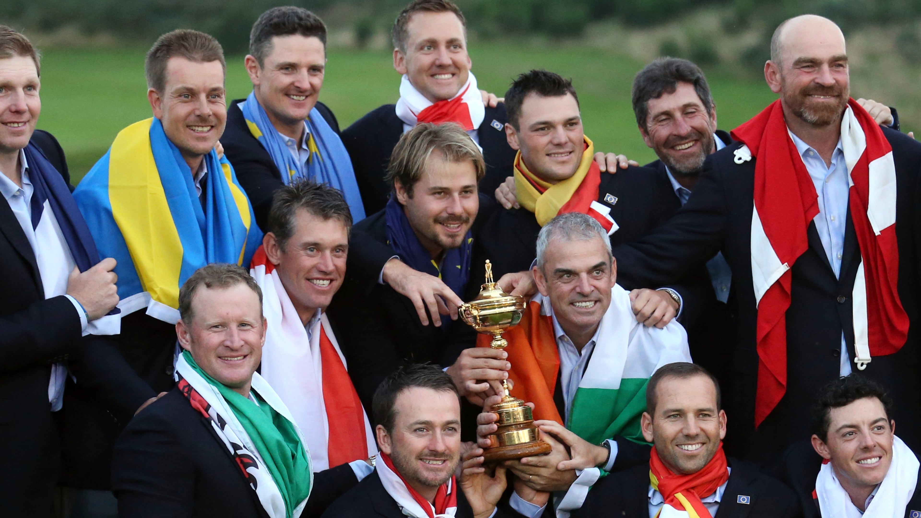 FILE - Europe team captain Paul McGinley, center right, and his team wear their national flags and celebrate with the trophy after winning the Ryder Cup golf tournament at Gleneagles, Scotland, Sunday, Sept. 28, 2014. (AP Photo/AP Photo/Peter Morrison, File)