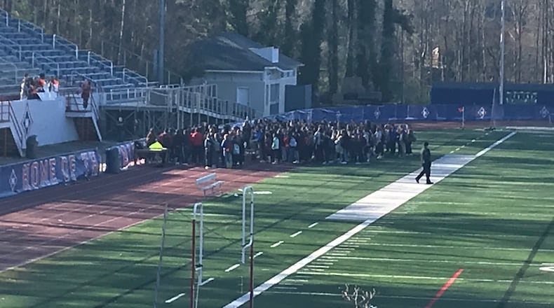 Walton High School students walk out onto the football field on March 14 as part of a national protest against gun violence that took place in schools across the country. Special to the AJC.