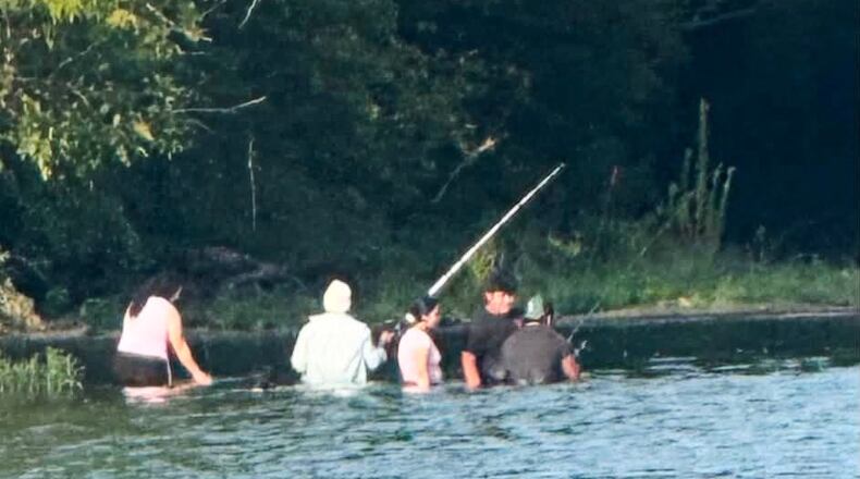 In this photo provided by Pastor Marcus L. Martin, a group of people he believes were those who died in a recent drowning accident, are shown fishing along the Scioto river in Powell, Ohio, Sunday, July 19, 2026. (Pastor Marcus L. Martin via AP)