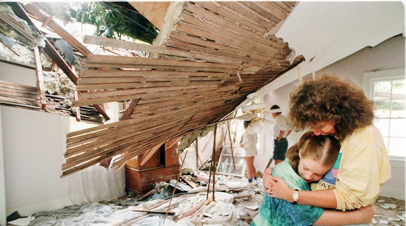 Mother/daughter, Mary Foltz, right, with nine-year-old daughter Katie share a moment together in the mother’s bedroom Thursday. A giant white oak tree crashed into the mothers room during the night as ‘Opal’ passed thru Atlanta. The mother was in bed when the tree crashed in. Mary and her two daughters were alone in the house during the storm. The other daughter, 12-year-old Melissa is in the background of this photo.