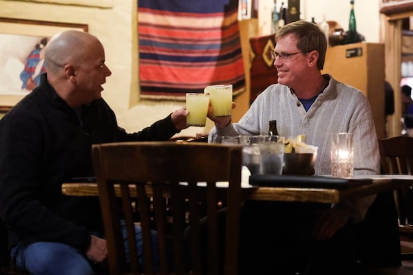 Dan Barnhart (left) lifts his glass with Jesse Hester at Agave on Friday, Jan. 23, 2026. Barnhart said Agave was the first restaurant he ate at when he moved to Atlanta 22 years ago, and he’s been a regular since. Hester has been a regular customer since they opened in 2000. (Abbey Cutrer/AJC)