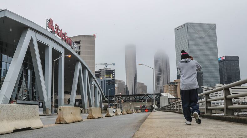 A pedestrian heads down Centennial Olympic Park Drive near State Farm Arena. Atlanta has had one of the worst rates of income disparity among U.S. cities, with the Black community especially hit hard. A new push by Atlanta businesses will try to address those problems. (John Spink / John.Spink@ajc.com)
