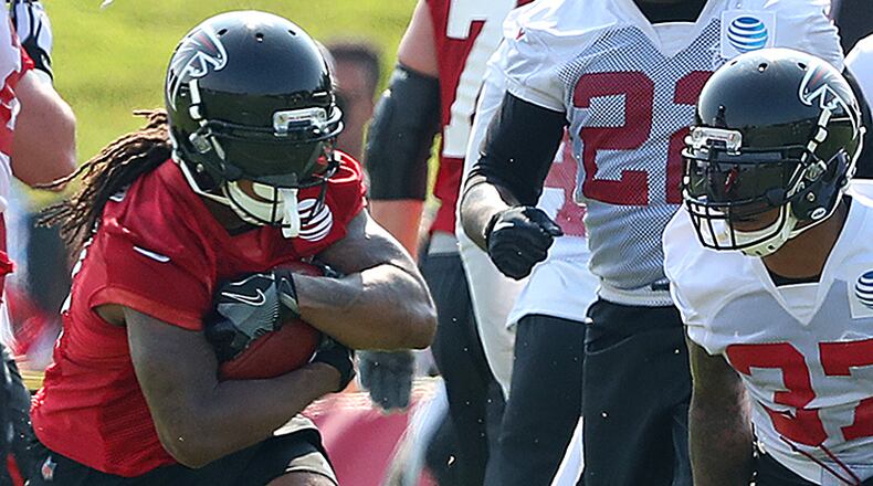 Falcons running back Devonta Freeman hits a hole for yardage on the first day of team practice at training camp on Thursday, July 27, 2017, in Flowery Branch.