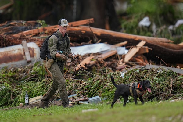 Officials comb through the banks of the Guadalupe River after a flash flood swept through the area Saturday, July 5, 2025, in Hunt, Texas. (AP Photo/Julio Cortez)