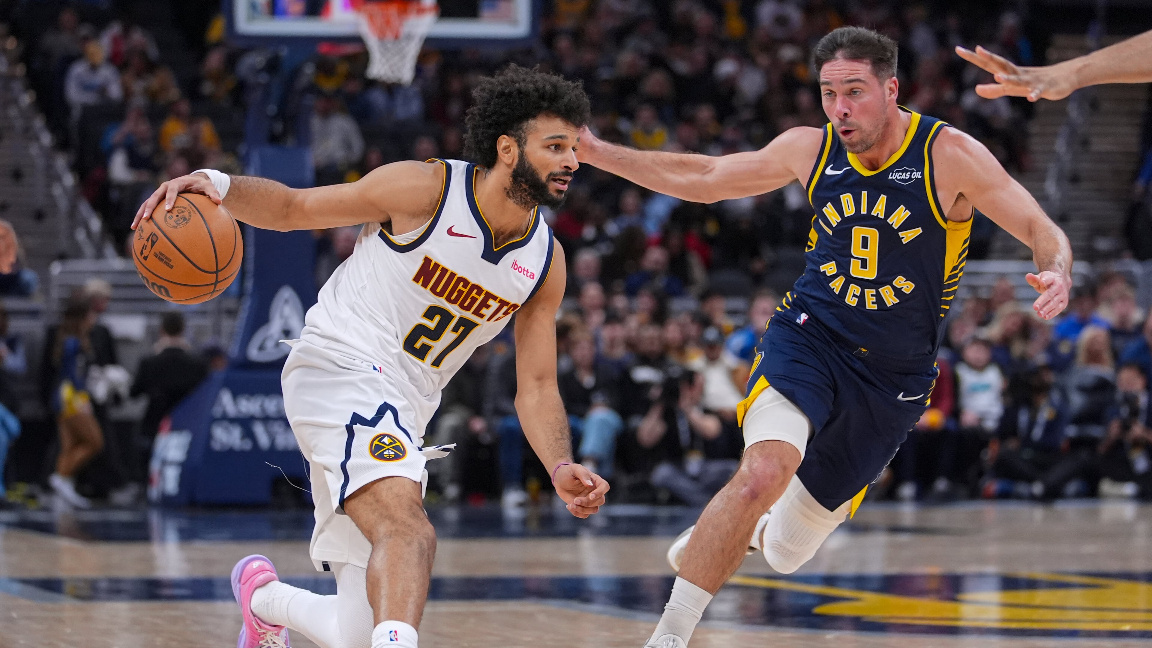 Denver Nuggets guard Jamal Murray (27) drives on Indiana Pacers guard T.J. McConnell (9) during the second half of an NBA basketball game in Indianapolis, Wednesday, Dec. 3, 2025. (AP Photo/Michael Conroy)