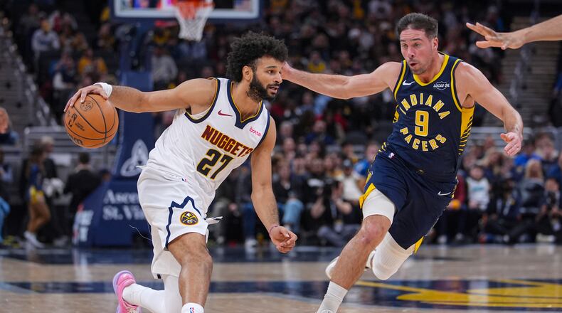 Denver Nuggets guard Jamal Murray (27) drives on Indiana Pacers guard T.J. McConnell (9) during the second half of an NBA basketball game in Indianapolis, Wednesday, Dec. 3, 2025. (AP Photo/Michael Conroy)