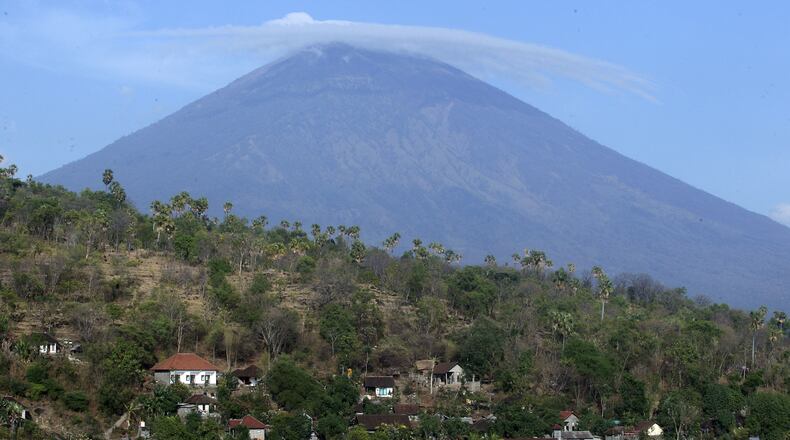 UPDATES CAPTION - Mount Agung volcano is seen in Amed, Bali, Indonesia, Tuesday, Sept. 26, 2017. More than 57,000 people have fled the surrounds of Mount Agung volcano on the Indonesian tourist island of Bali, fearing an imminent eruption, officials said Tuesday. (AP Photo/Firdia Lisnawati)