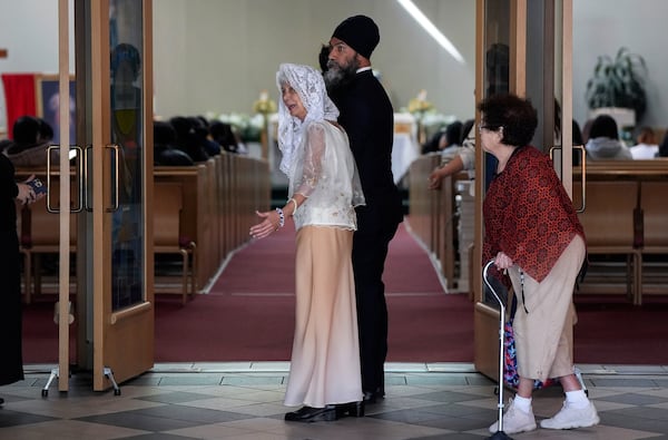 NDP Leader Jagmeet Singh walks with Rosita Taruc, front centre, as he arrives to attend mass at St. Mary's Parish, after multiple people that were stuck by a car were killed on Saturday at a Filipino heritage festival in Vancouver, British Columbia, Sunday, April 27, 2025. Darryl Dyck/The Canadian Press via AP)