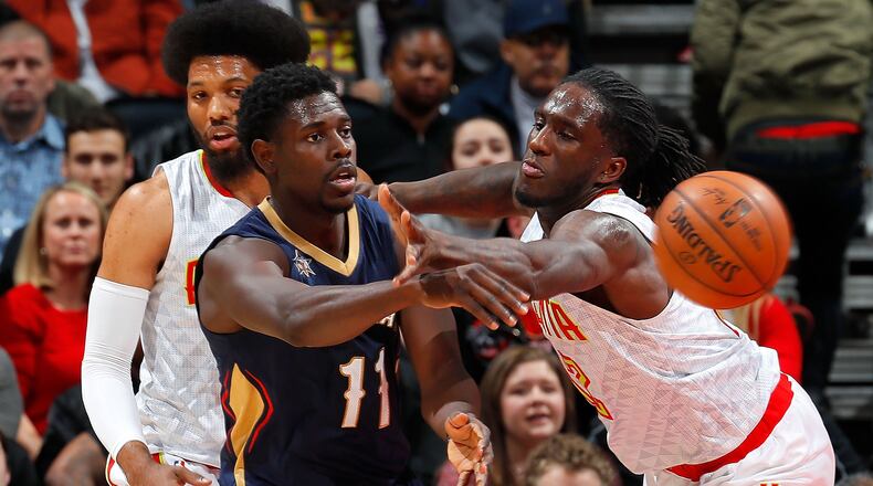 Jrue Holiday (center) the New Orleans Pelicans passes the ball against Taurean Prince (right) and DeAndre Bembry (left) of the Atlanta Hawks at Philips Arena on November 22, 2016 in Atlanta, Georgia. (Photo by Kevin C. Cox/Getty Images)