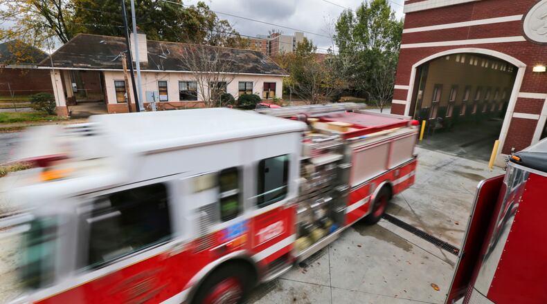 FIREHOUSE FOR SALE--November 7, 2013 Atlanta: Engine 13 leaves the house on Thursday, Nov. 7, 2013 as the old firehouse (background) is now for up for sale. The City of Atlanta this week began accepting bids on the Flat Shoals Avenue building that housed the firefighters of Station 13 for nearly 90 years. The 2148-square-foot fire house opened in 1921 on just under a quarter-acre of land in the 400 block of Flat Shoals Avenue in southeast Atlanta. It's been vacant since a new Station 13 was built across Metropolitan Avenue in 2010, according to Mark Haldane, real estate asset manager for the city. Bids, which must include a certified check or surety bond for 10 percent of the bid price, will be accepted through Dec. 20, Haldane told The Atlanta Journal-Constitution. Potential bidders can inspect the property from 1 to 5 p.m. on Nov. 20, he said. The building is being sold as is, and if you've always dreamed of having a fire pole to slide down after getting out of bed every morning, you're out of luck, because the station is a single-story building. JOHN SPINK/JSPINK@AJC.COM
