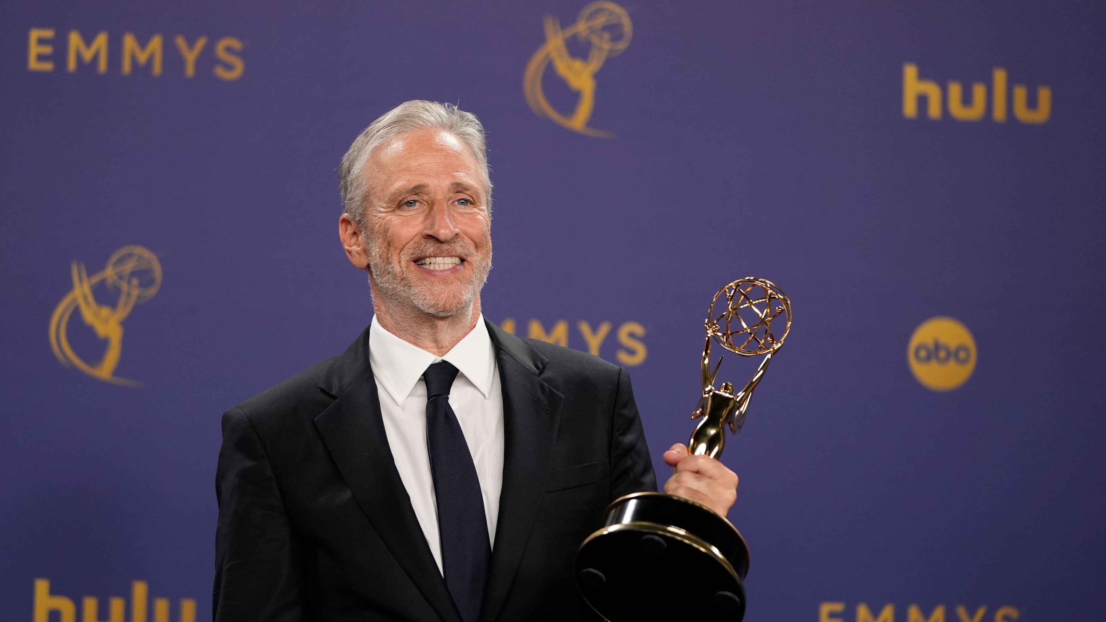 FILE - Jon Stewart poses in the press room with the award for outstanding talk series for "The Daily Show" during the 76th Primetime Emmy Awards on Sept. 15, 2024, at the Peacock Theater in Los Angeles. (AP Photo/Jae C. Hong, File)