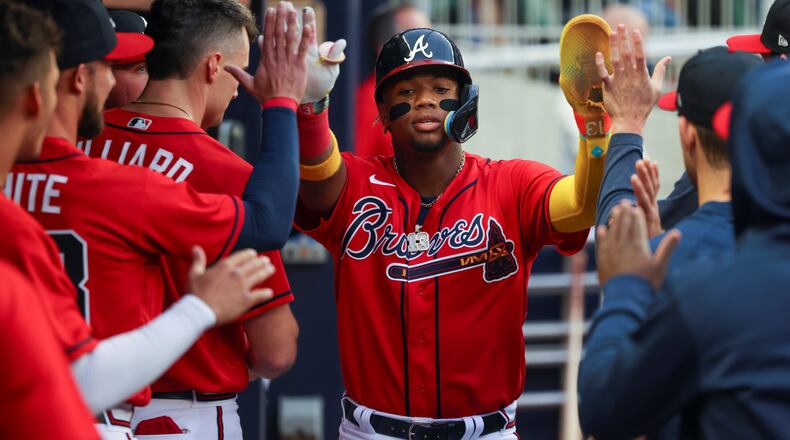Ronald Acuna celebrates a run with teammates during the first inning against the Houston Astros at Truist Park, Friday, April 21, 2023, in Atlanta.