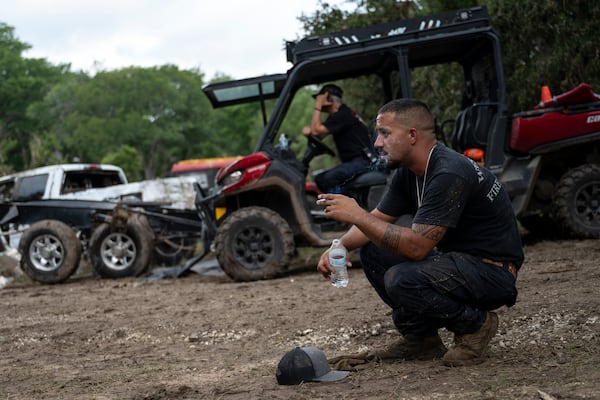 West Odessa Volunteer Firefighter Jed Wolske takes a smoke break while aiding in search and rescue efforts along the Guadalupe River after a flash flood swept through the area, Monday, July 7, 2025, in Ingram, Texas. (AP Photo/Eli Hartman)