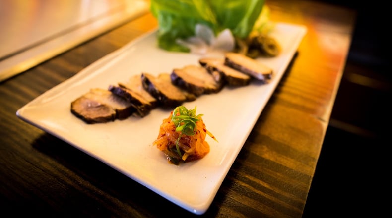A plate of bossam includes braised pork belly, lettuce wraps and house-made kimchi. (Theodore Williams)