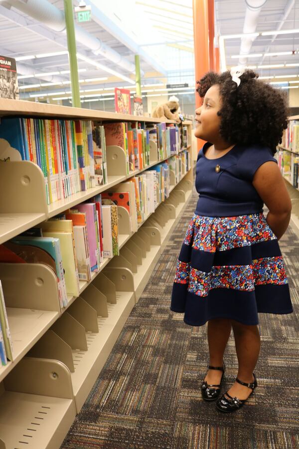 Daliyah Arana peruses the bookshelves at the Southeast Atlanta Library, where she got the chance to be librarian for a day recently. The 5-year-old has read more than 1,000 books and counting. CONTRIBUTED BY RACHEL DANIELS / ATLANTA-FULTON PUBLIC LIBRARY SYSTEM