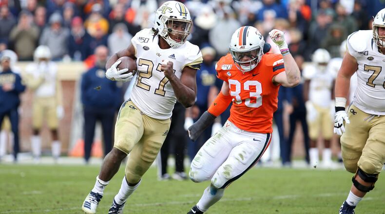 Jordan Mason #27 of the Georgia Tech Yellow Jackets rushes past Zane Zandier #33 of the Virginia Cavaliers in the second half during a game at Scott Stadium on November 9, 2019 in Charlottesville, Virginia. (Photo by Ryan M. Kelly/Getty Images)