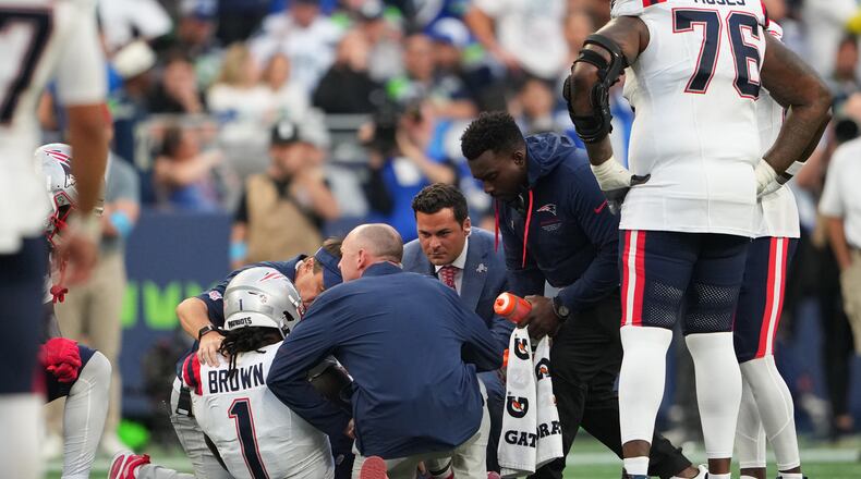 New England Patriots wide receiver A.J. Brown (1) is tended to on the field during the second half of an NFL football game against the Seattle Seahawks, Wednesday, Sept. 9, 2026, in Seattle. (AP Photo/Lindsey Wasson)